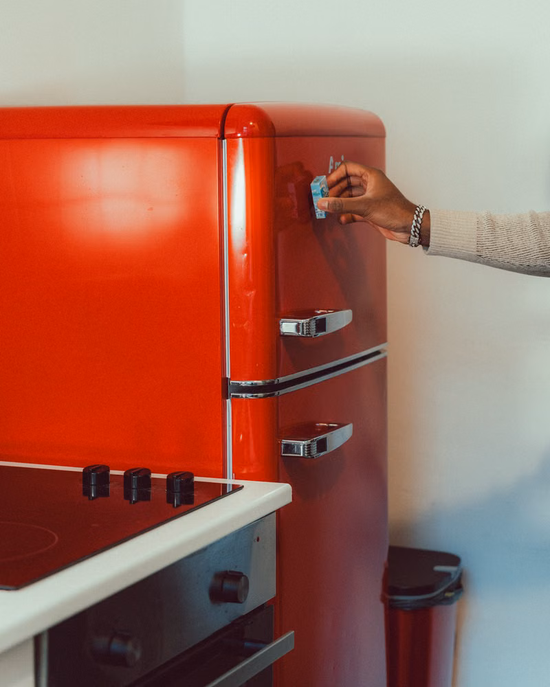Junk removal worker removing an old refrigerator from a kitchen